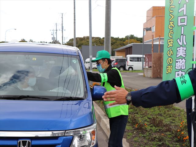 <p>　署員と各学校の通学路や空き家の巡回確認など、地域の安全を守る活動をしている自主防犯パトロール隊メンバーが参加しました。
　警察署前で通行するドライバーに啓発チラシを配布した後、青色回転灯を付けたパトロール車やパトカーが出動し、町内を巡回しました。</p>